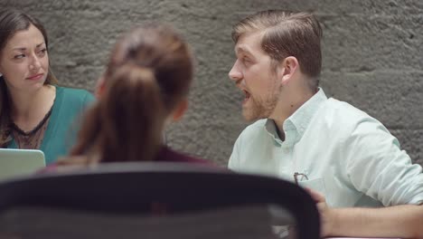 Hombre-hablando-con-sus-colegas-en-una-reunión-de-negocios-pequeños