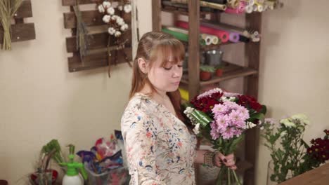 Blumengeschäft-sammelt-Blumenarrangements,-eine-Frau-hält-Chrysanthemen-in-ihren-Händen