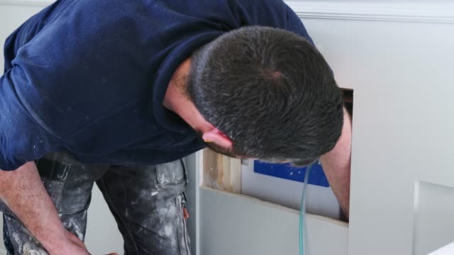 Plumber-Fitting-New-Bathroom-Reaching-Into-Wall-Cavity