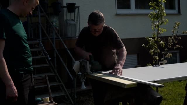 father-and-son-repair-the-inner-doors-in-the-garden-in-the-fresh-air