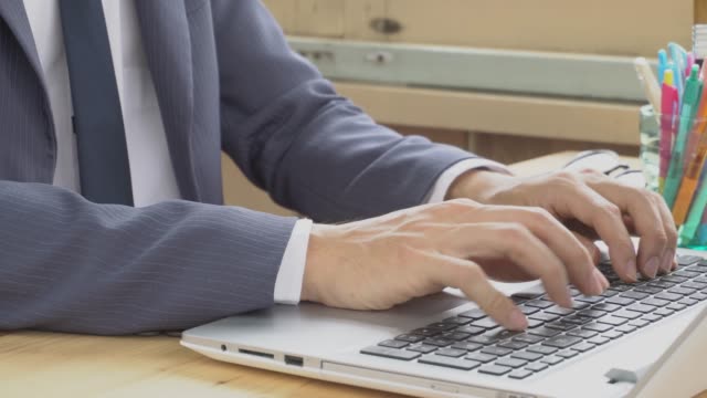 Hombre-de-negocios-en-traje-de-escribir-portátil-en-oficina-en-casa.-Trabajo-y-la-comunicación-por-Internet