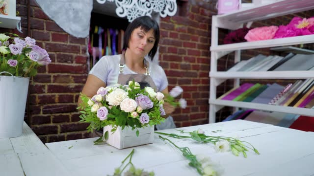 professionellen-Floristen-arrangieren-schöne-Blume-Zusammensetzung-in-Holzkiste-im-floralen-Designstudio