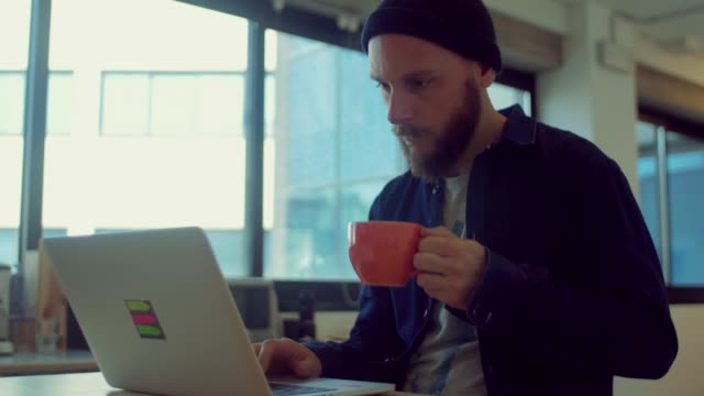 Man-drinks-coffee-while-working-in-the-startup-office