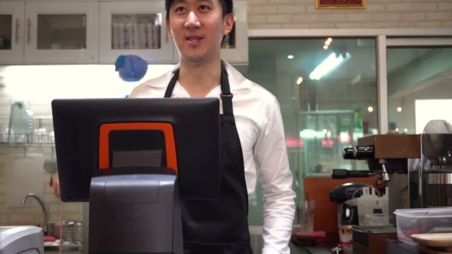 Café-hombre-asiático-joven-barista-personal-dando-la-bienvenida-y-saludar-a-los-clientes-en-el-restaurante-café