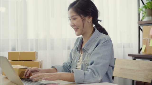 Schöne-intelligente-asiatischen-jungen-Unternehmer-Frau-Eigentümer-von-KMU-Online-Check-Produkt-auf-Lager-und-speichern-auf-Computer-zu-Hause-arbeiten.-Kleinunternehmer-im-home-Office-Konzept.