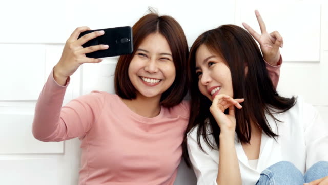 Schönes-paar-Frauen-Selfie-zusammen-mit-attraktiven-Lächeln-auf-den-Lippen.-Asiatische-Frauen-mit-Kamera-im-Smartphone-für-Selfie-zusammen.