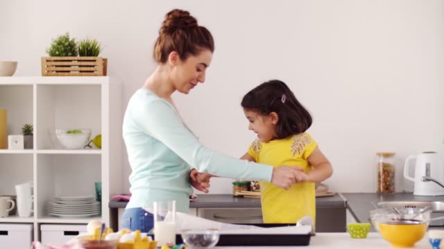 Mutter-mit-Tochter-Kochen-und-tanzen-zu-Hause