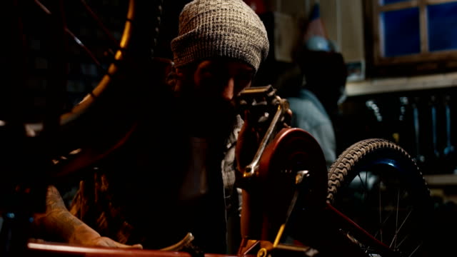 Dos-hombres-trabajando-en-un-taller-de-reparación-de-bicicletas