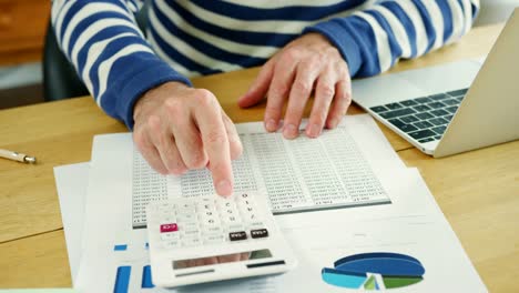 Hombre-de-negocios-análisis-y-cálculo-de-datos-financieros-en-su-escritorio