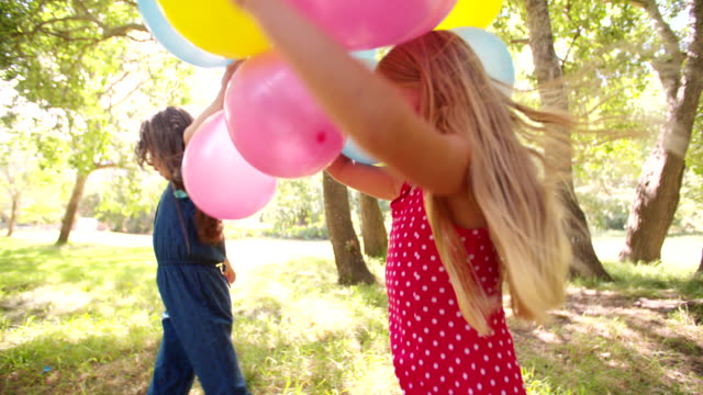 Freundliche-glückliche-Kinder-Spaß-mit-Luftballons-im-Freien