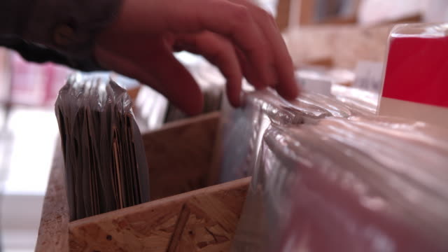 Close-up-of-hands-sorting-through-records-at-a-record-shop