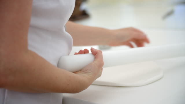 Frau-Rollen-Vereisung-In-der-Bäckerei-zur-Verzierung-von-Kuchen
