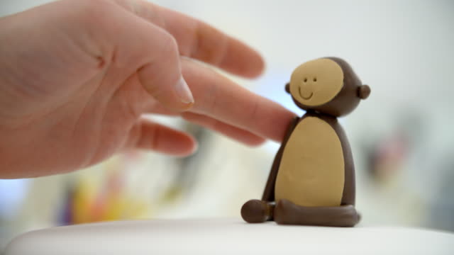 Close-Up-Of-Woman-In-Bakery-Making-Monkey-Cake-Decoration