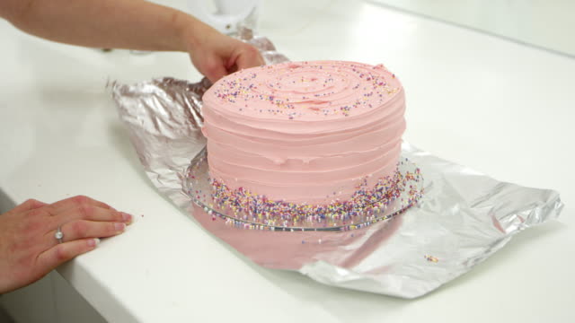 Mujer-en-la-panadería-decorar-pastel-con-cubierta-de-crema