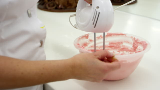 Close-Up-Of-Woman-In-Bakery-Whisking-Icing-For-Decoration