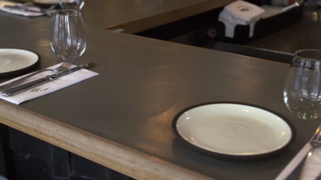 Place-settings-at-bar-in-an-empty-restaurant,-camera-slider