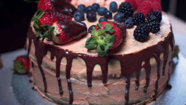 4K-Cake-Baker-Decorating-with-Berries-and-Cream