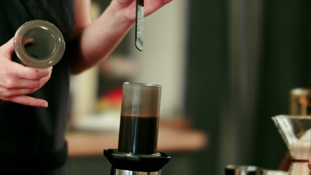Barista-bereitet-schwarzen-Kaffee-mit-dem-aeropress