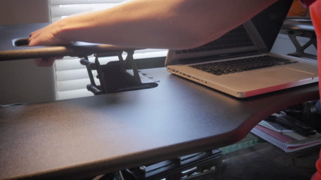 Woman-Changes-the-Height-on-a-Variable-Standing-Desk
