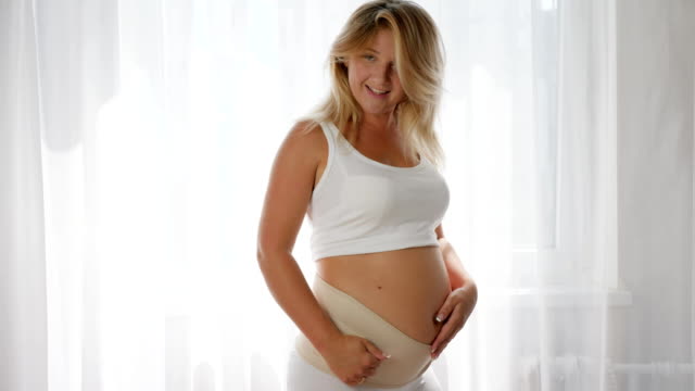 Nahaufnahme-von-Mädchen-posiert-vor-der-Kamera-in-einem-Verband-für-den-Komfort-der-schwangeren