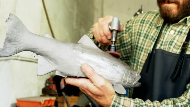 Artesano-en-pulido-de-escultura-de-los-pescados-4k
