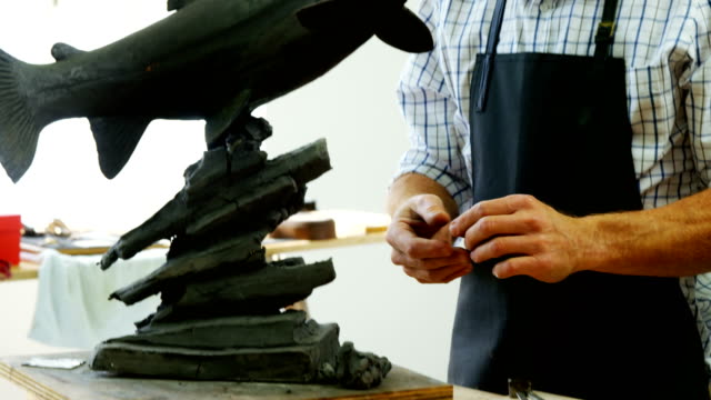 Handwerker-arbeiten-an-Fisch-Skulptur-4k