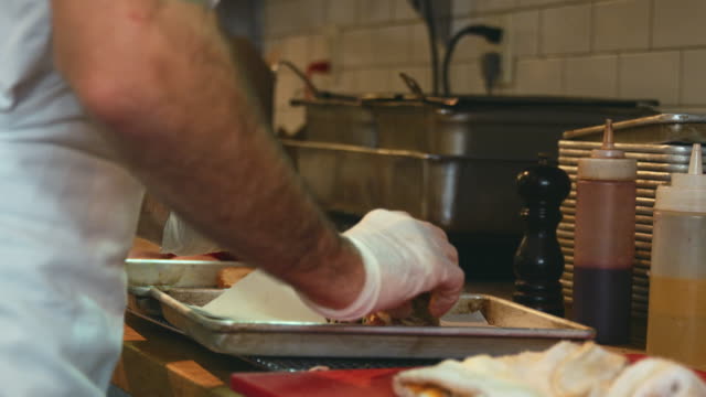 Man-in-a-delicatessen-preparing-a-sandwich,-close-up