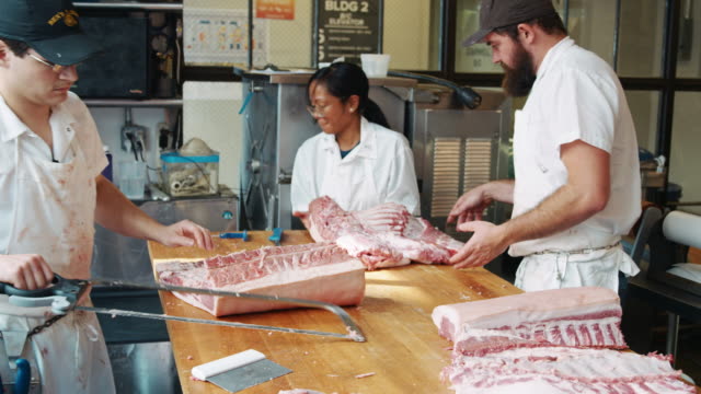 Tres-carniceros-preparando-carne-en-una-carnicería