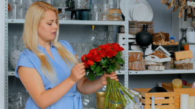 lächelnde-Florist-Frau-machen-Menge-im-Blumenladen