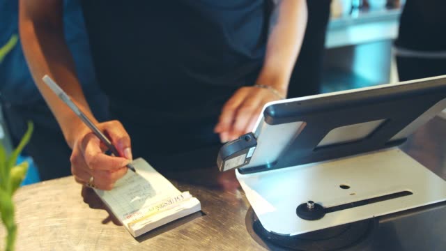 Close-Up-Of-Waitress-Totaling-Bill-At-Coffee-Shop-Checkout