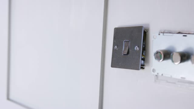 Close-Up-Of-Electric-Light-Switches-And-Dimmers-Being-Fitted