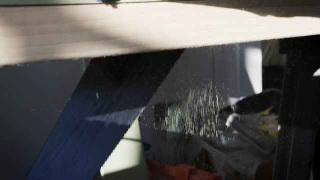 Close-Up-Of-Carpenter-Sawing-Timber-Indoors