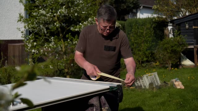 Vater-und-Sohn-reparieren-die-Innentüren-im-Garten-an-der-frischen-Luft