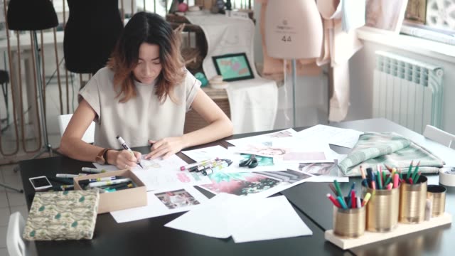 designer-of-clothes-makes-a-sketch-of-clothes-in-a-sewing-workshop.-a-girl-working-for-herself-is-busy-with-creative-work