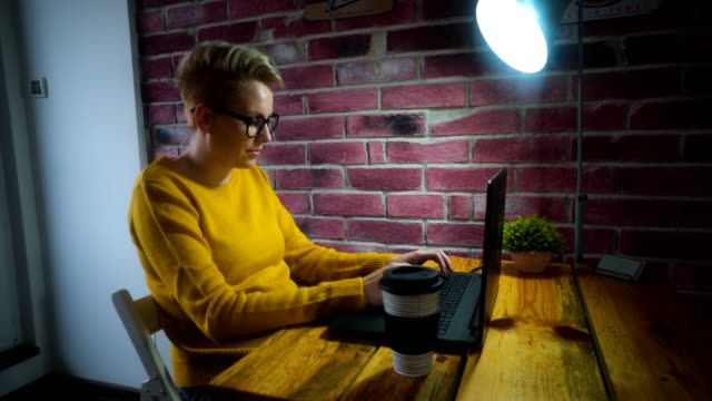 Attraktive-junge-Frau-an-der-Rezeption-mit-einem-Laptop-im-home-Office.