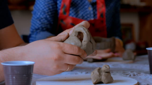 Man-making-mug-in-pottery-studio-workshop