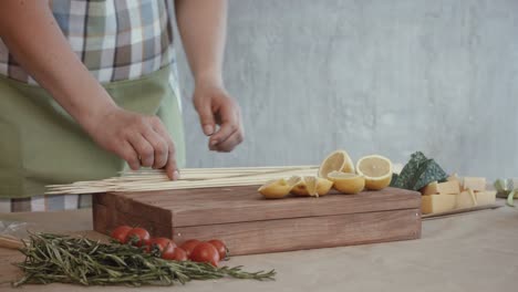 Female-hands-pinning-slices-of-lemon-on-skewers