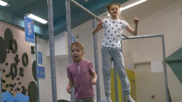 Zwei-Mädchen-auf-Indoor-Trampolin-Springen