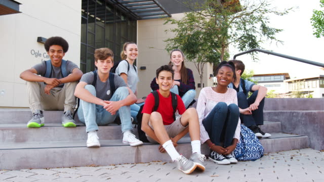 Portrait-Of-High-School-Student-Group-Sitting-Outside-College-Buildings
