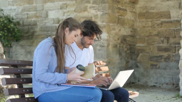 pareja-de-jóvenes-estudiantes-hombre-y-mujer-trabajando-con-el-ordenador-portátil-al-aire-libre-en-una-calle-durante-el-verano