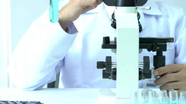 Männliche-Wissenschaftler-auf-der-Suche-durch-Mikroskop-und-beobachten-Sie-im-modernen-Labor-oder-medizinisches-Zentrum.-Begriff-von-Wissenschaft,-Entwicklung-und-Labor-Industrie-testen.