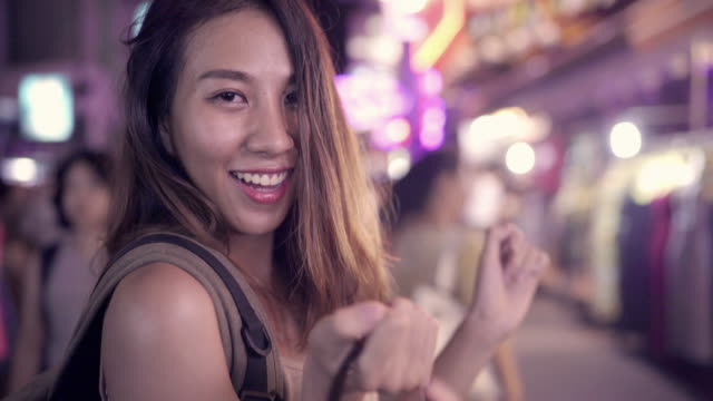 Young-Asian-traveling-women-backpacker-drinking-alcohol-or-beer-and-dancing-in-urban-street-night-party-at-The-Khao-San-Road-in-Bangkok,-Thailand.-Traveler-and-tourist-concept.