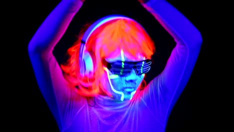 Mujer-con-pintura-Ultravioleta-de-la-cara-de-cyborg,-peluca,-brillantes-gafas,-ropa-bailando-y-escuchando-música-con-auriculares.-Mujer-asiática.-.