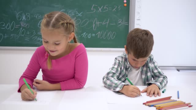 Privatschule,-ziehen-Kinder-Farbmarkierungen-auf-weißem-Papier-beim-Sitzen-am-Schreibtisch-im-Klassenzimmer