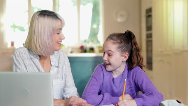 Female-Home-Tutor-Helping-Young-Girl-With-Studies