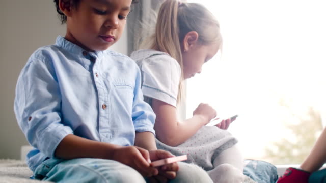 African-Boy-and-Caucasian-Girl-Playing-on-Smartphones