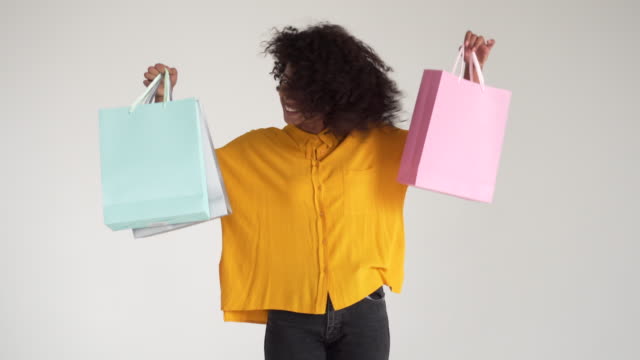 Afroamerikanische-Frau-hält-Einkaufstaschen-und-Tanz