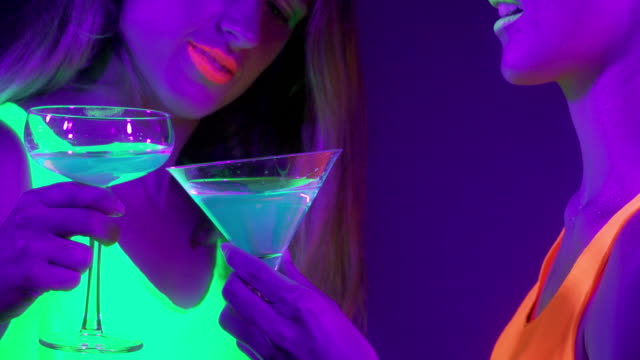 Langsame-Motin-von-schönen-sexy-Frauen-mit-fluoreszierenden-Make-up-und-Kleidung-Tanz-im-Neonlicht.-Night-Club,-Party-Konzept.