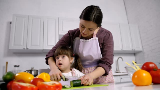 Behinderte-Down-Syndrom-Kind-mit-Mutter-kochen