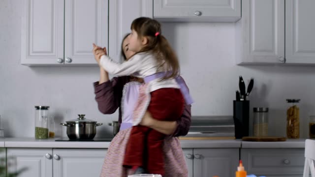 Fröhliche-Mama-und-besonderen-Bedürfnissen-Kind-tanzen-in-Küche